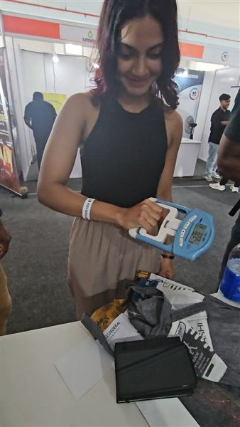 A participant measuring grip strength with a digital dynamometer