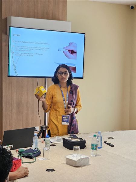 A physician demonstrating a continuous glucose monitor during a health education session