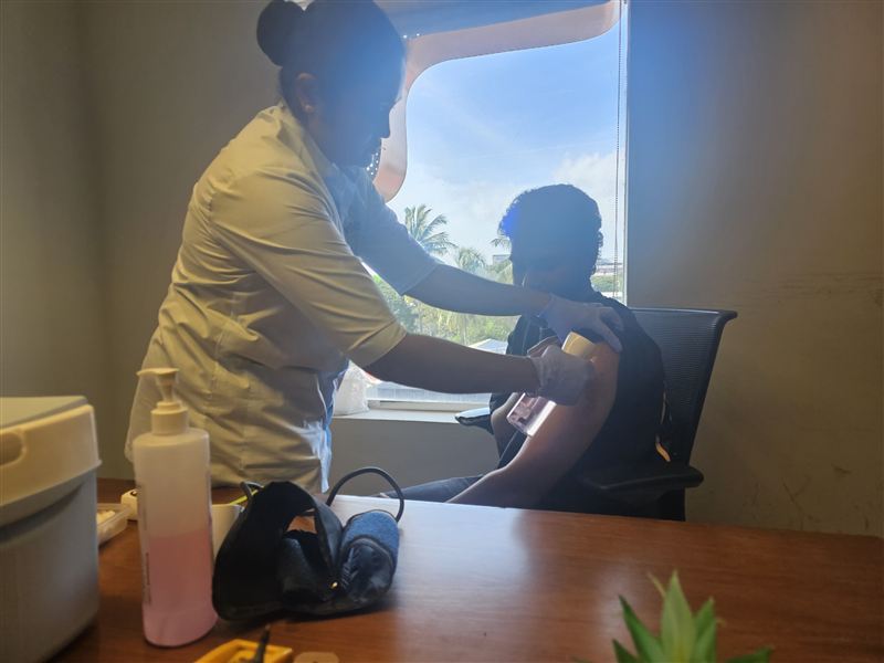 A nurse vaccinating an employee at a workplace camp