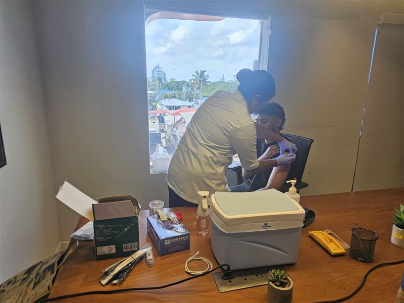 A vaccination being given under clinical supervision at a workplace